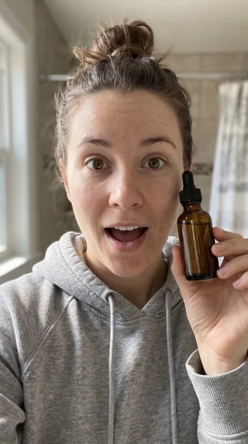 A skincare reel: a woman holds up a serum dropper